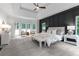 Spacious main bedroom with a tray ceiling, accent wall, sitting area, and plenty of natural light from multiple windows at 12995 Bucksport Dr, Roswell, GA 30075