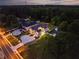 Twilight aerial view of custom home featuring manicured landscaping, elegant exterior lighting, and private driveway at 157 Shadburn Ferry Rd, Buford, GA 30518