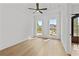 Bright bedroom features hardwood floors, a ceiling fan and two large windows with neighborhood views at 157 Shadburn Ferry Rd, Buford, GA 30518