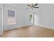 Bright bedroom with hardwood floors, two windows, and modern ceiling fan at 157 Shadburn Ferry Rd, Buford, GA 30518