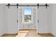 Bedroom with stylish barn door leading to built in shelving and neighborhood views at 157 Shadburn Ferry Rd, Buford, GA 30518