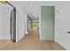 Bright hallway featuring hardwood floors, white walls, and a modern green accent wall at 157 Shadburn Ferry Rd, Buford, GA 30518