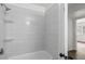 Bright bathroom featuring a shower over tub and glass shelving at 169 Peyton Sw Pl, Atlanta, GA 30311