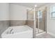 Modern bathroom featuring a soaking tub and a separate glass-enclosed shower with tile surround at 791 Belrose Dr, Smyrna, GA 30080