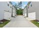 Rear view of multiple townhome-style residences, each with a single-car garage and private driveway at 791 Belrose Dr, Smyrna, GA 30080