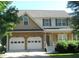 Charming two-story home featuring a stone facade, two-car garage, and well-maintained front lawn at 4750 Crinklepoint Ct, Douglasville, GA 30134