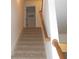 Carpeted stairway leading to the upper level with a wood railing at 4750 Crinklepoint Ct, Douglasville, GA 30134