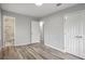A bedroom with gray walls, wood floors, closet, and an ensuite bathroom with white tile shower and toilet at 6565 Bussell Way, Riverdale, GA 30274