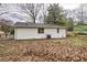 View of the exterior back of a white brick single story home, with leaves on the ground and a small yard at 6565 Bussell Way, Riverdale, GA 30274