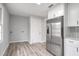 Modern kitchen with stainless steel appliances, white cabinets, tile backsplash, and a door with a laundry hookup at 6565 Bussell Way, Riverdale, GA 30274