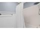 Bathroom featuring a white bathtub with white tile walls and shower with white curtain and chrome fixtures at 2525 Millwater Xing, Dacula, GA 30019