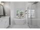 Elegant bathroom featuring a soaking tub, tiled shower, and shiplap wall paneling at 2525 Millwater Xing, Dacula, GA 30019