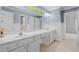 Bright bathroom with double sink vanity, white cabinets, wainscoting and a view to the commode and standing shower at 2525 Millwater Xing, Dacula, GA 30019