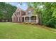 Traditional brick home with a covered front porch, manicured lawn, and mature landscaping at 2525 Millwater Xing, Dacula, GA 30019