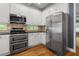 Bright kitchen featuring stainless steel appliances, white cabinets, and tiled backsplash at 2525 Millwater Xing, Dacula, GA 30019