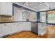 Modern kitchen featuring white cabinets, dark countertops, stainless steel appliances, and hardwood floors at 2525 Millwater Xing, Dacula, GA 30019