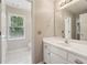Bright bathroom featuring a vanity with white cabinets, framed mirror, and a large window view to the toilet at 340 Old York Rd, Johns Creek, GA 30097