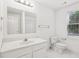 Bathroom with a single sink vanity, large mirror, toilet, and a large window letting in natural light at 340 Old York Rd, Johns Creek, GA 30097