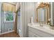 Charming bathroom featuring stylish striped wallpaper, a vanity, and a shower/tub combination with a window at 340 Old York Rd, Johns Creek, GA 30097
