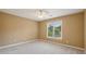 Cozy bedroom showcasing a ceiling fan, plush carpeting, and natural light streaming through a window at 340 Old York Rd, Johns Creek, GA 30097