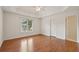 Bright bedroom with wood floors, neutral walls, a ceiling fan, and a door leading to the ensuite bathroom at 340 Old York Rd, Johns Creek, GA 30097