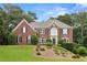 Charming two-story brick home boasts manicured landscaping and lush trees at 340 Old York Rd, Johns Creek, GA 30097