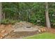 Outdoor stone firepit surrounded by natural landscaping in a lush backyard at 340 Old York Rd, Johns Creek, GA 30097