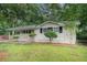 Single-story home surrounded by mature trees and a well-maintained lawn at 1026 Eisenhower Se Ct, Atlanta, GA 30354