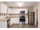 An open kitchen includes stainless steel appliances, white cabinets, and hardwood floors at 1026 Eisenhower Se Ct, Atlanta, GA 30354