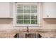 Granite countertops surround a stainless steel dual kitchen sink beneath a window with white blinds at 1026 Eisenhower Se Ct, Atlanta, GA 30354