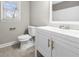 Bathroom featuring a white vanity with modern fixtures and a toilet with a gray accent wall at 1192 Melton Sw Dr, Lilburn, GA 30047