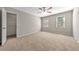 Spacious main bedroom with neutral carpet, a ceiling fan, and an attached closet at 1192 Melton Sw Dr, Lilburn, GA 30047