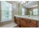 Bathroom with natural wood vanity, double sinks, ample counter space, and a mirror at 2563 Creek Ter, Snellville, GA 30078