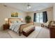 Cozy bedroom featuring a tray ceiling, ample natural light, and neutral decor at 2563 Creek Ter, Snellville, GA 30078