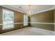 A spacious dining room features a chandelier, neutral walls, and a large window at 2563 Creek Ter, Snellville, GA 30078