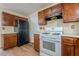 Traditional kitchen with wood cabinets, white appliances, and updated flooring at 2563 Creek Ter, Snellville, GA 30078