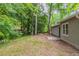 Backyard view of home featuring a small patio area, green grass, and mature shade trees at 4164 Little Nw Spgs, Kennesaw, GA 30144