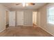 The bedroom features neutral colored walls with carpet flooring, a ceiling fan, and three white doors at 4164 Little Nw Spgs, Kennesaw, GA 30144