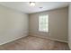 A bedroom with neutral walls, carpet flooring, a window, and a ceiling light at 4164 Little Nw Spgs, Kennesaw, GA 30144