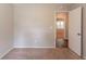 A bedroom featuring neutral colored walls with carpet flooring, a view into the next room, and a white door at 4164 Little Nw Spgs, Kennesaw, GA 30144