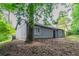 Angled exterior showing neutral siding, a small patio, and mature landscaping at 4164 Little Nw Spgs, Kennesaw, GA 30144
