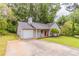 Inviting home showcasing a paved driveway and a well-manicured lawn with mature trees in the background at 4164 Little Nw Spgs, Kennesaw, GA 30144