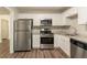 Modern kitchen featuring stainless steel appliances, granite countertops, and sleek white cabinetry at 4164 Little Nw Spgs, Kennesaw, GA 30144