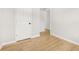 A bedroom with hardwood flooring, two doors, and white baseboards at 4420 Ross Estates Ct, Snellville, GA 30039