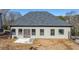 Rear view of home with light-grey siding, dark-grey roof, windows, and door to newly-poured concrete patio at 4420 Ross Estates Ct, Snellville, GA 30039