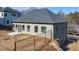 Back exterior of home, showing light-grey siding, dark-grey roof, and newly-poured concrete patio at 4420 Ross Estates Ct, Snellville, GA 30039