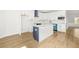 Modern kitchen with white cabinets, a white island, stainless steel appliances, and hardwood floors at 4420 Ross Estates Ct, Snellville, GA 30039