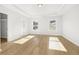 Open main bedroom with hardwood floors, tray ceiling, and two windows for natural light at 4420 Ross Estates Ct, Snellville, GA 30039
