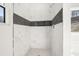 Modern shower with white marble tile, dark accent stripe, and a built-in niche at 4420 Ross Estates Ct, Snellville, GA 30039