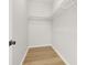 A well-organized walk-in closet featuring wood flooring and white shelving at 4420 Ross Estates Ct, Snellville, GA 30039